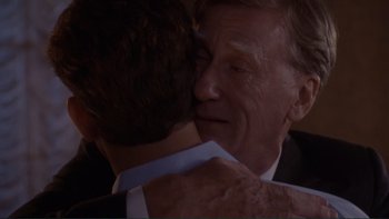 Movie still from “The Bonfire of the Vanities” (1990), directed by Brian De Palma – An older man hugging a younger man in front of a window; Close Up shot, Over the shoulder angle