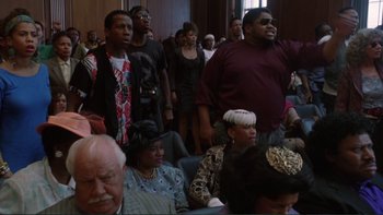 Movie still from “The Bonfire of the Vanities” (1990), directed by Brian De Palma – A group of people standing in a room; Medium shot, Low angle