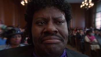 Movie still from “The Bonfire of the Vanities” (1990), directed by Brian De Palma – A person wearing a suit and tie; Close Up shot, Low angle