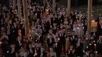 Movie still from “The Bonfire of the Vanities” (1990), directed by Brian De Palma – A large group of people in formal wear holding candles; Extreme Wide shot, High angle
