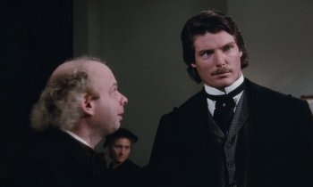 Movie still from “The Bostonians” (1984), directed by James Ivory – A man in a suit and tie standing next to another man in a suit and tie; Medium shot, Over the shoulder angle