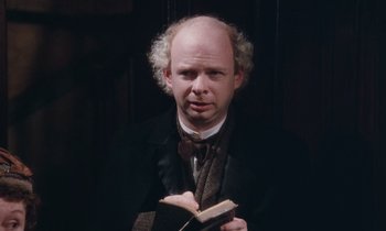 Movie still from “The Bostonians” (1984), directed by James Ivory – A man with a book in his hands; Close Up shot, High angle
