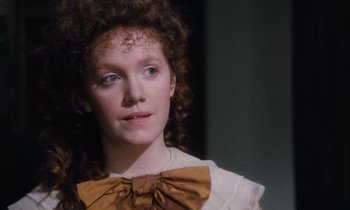 Movie still from “The Bostonians” (1984), directed by James Ivory – A woman with a bow tie is looking at the camera; Close Up shot, High angle