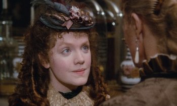 Movie still from “The Bostonians” (1984), directed by James Ivory – A young girl wearing a hat and a dress; Close Up shot, Over the shoulder angle