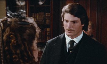 Movie still from “The Bostonians” (1984), directed by James Ivory – A man wearing a suit and tie in front of a woman wearing a hat; Close Up shot, Over the shoulder angle