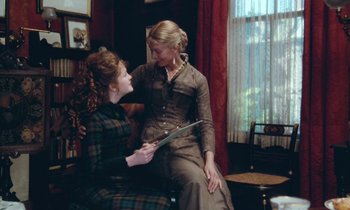 Movie still from “The Bostonians” (1984), directed by James Ivory – Two young women sitting in a living room; Medium shot, Over the shoulder angle