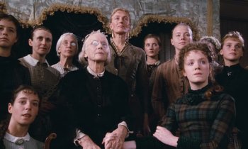 Movie still from “The Bostonians” (1984), directed by James Ivory – A group of people standing next to each other in a room; Medium shot, Low angle