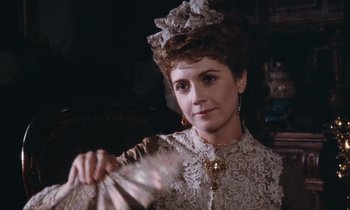 Movie still from “The Bostonians” (1984), directed by James Ivory – A woman holding a fan while wearing a dress; Close Up shot, Over the shoulder angle