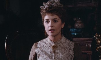 Movie still from “The Bostonians” (1984), directed by James Ivory – A woman in a white dress and a bow in her hair; Close Up shot, Over the shoulder angle