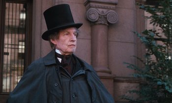 Movie still from “The Bostonians” (1984), directed by James Ivory – An older man wearing a top hat and a long coat; Close Up shot, Low angle