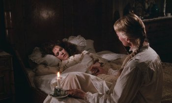 Movie still from “The Bostonians” (1984), directed by James Ivory – A woman in a bed with a lit candle; Medium shot, High angle