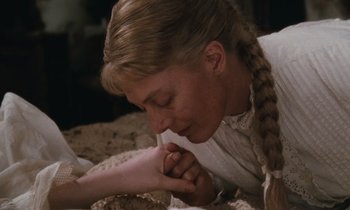 Movie still from “The Bostonians” (1984), directed by James Ivory – A young woman is laying down with her head resting on her hand; Close Up shot, High angle