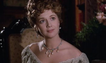 Movie still from “The Bostonians” (1984), directed by James Ivory – A person wearing a necklace and earrings; Close Up shot, Over the shoulder angle