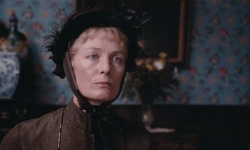 Movie still from “The Bostonians” (1984), directed by James Ivory – An older woman wearing a black hat and a brown dress; Close Up shot, Low angle