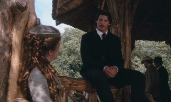 Movie still from “The Bostonians” (1984), directed by James Ivory – A man in a suit sitting next to a woman in a black suit; Medium shot, Low angle