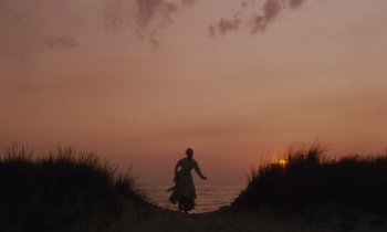 Movie still from “The Bostonians” (1984), directed by James Ivory – A person walking on the beach at sunset; Extreme Wide shot, Low angle