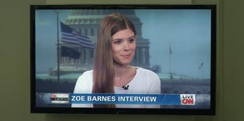 Movie still from “House of Cards” (2013), created by Beau Willimon – A woman is sitting in front of a television; Medium shot, Over the shoulder angle