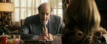 Movie still from “The Box” (2009), directed by Richard Kelly – An older man sitting at a table in front of a woman; Close Up shot, Over the shoulder angle