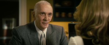 Movie still from “The Box” (2009), directed by Richard Kelly – An older man wearing a suit and tie; Close Up shot, Over the shoulder angle