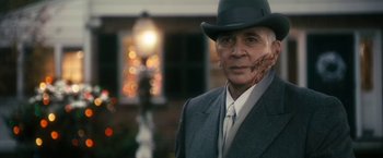 Movie still from “The Box” (2009), directed by Richard Kelly – An older man wearing a suit and a hat; Close Up shot, Over the shoulder angle