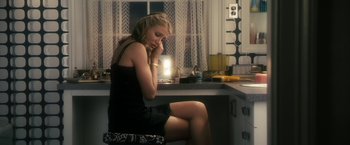 Movie still from “The Box” (2009), directed by Richard Kelly – A woman sitting on a stool in a kitchen; Medium shot, High angle