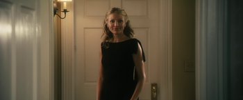 Movie still from “The Box” (2009), directed by Richard Kelly – A woman standing in front of a door wearing a black dress; Medium shot, Low angle