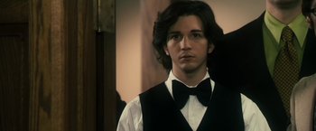 Movie still from “The Box” (2009), directed by Richard Kelly – A young man in a black vest and bow tie; Close Up shot, Over the shoulder angle