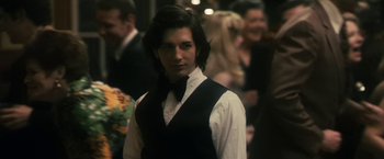 Movie still from “The Box” (2009), directed by Richard Kelly – A man with long black hair wearing a black vest; Medium shot, Over the shoulder angle