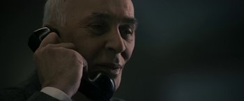 Movie still from “The Box” (2009), directed by Richard Kelly – An older man talking on a phone while wearing a suit; Close Up shot, Low angle