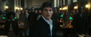 Movie still from “The Box” (2009), directed by Richard Kelly – A man standing in front of a group of people; Medium shot, Over the shoulder angle