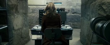 Movie still from “The Box” (2009), directed by Richard Kelly – A woman sitting in front of a computer desk; Medium shot, High angle