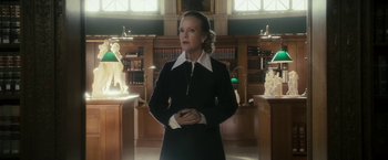 Movie still from “The Box” (2009), directed by Richard Kelly – A woman standing in front of a bookshelf in a library; Medium shot, Low angle