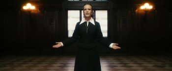 Movie still from “The Box” (2009), directed by Richard Kelly – A woman standing in front of a window with her arms outstretched; Medium shot, Low angle