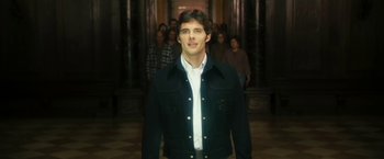 Movie still from “The Box” (2009), directed by Richard Kelly – A man standing in front of a group of people; Medium shot, Over the shoulder angle