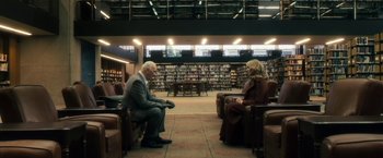 Movie still from “The Box” (2009), directed by Richard Kelly – A man and a woman are sitting in a library; Wide shot, High angle