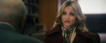 Movie still from “The Box” (2009), directed by Richard Kelly – A person sitting in a chair wearing a jacket; Close Up shot, Over the shoulder angle