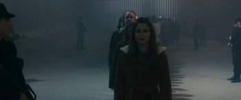 Movie still from “The Box” (2009), directed by Richard Kelly – A group of people standing in a dark room; Medium shot, High angle