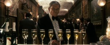 Movie still from “The Box” (2009), directed by Richard Kelly – A man standing in front of a row of champagne flutes; Medium shot, Over the shoulder angle