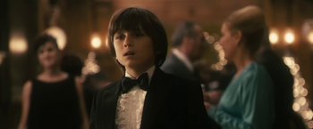 Movie still from “The Box” (2009), directed by Richard Kelly – A boy in a suit and a bow tie; Close Up shot, Over the shoulder angle