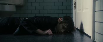 Movie still from “The Box” (2009), directed by Richard Kelly – A young boy laying on the ground in a dark room; Close Up shot, High angle