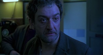 Movie still from “The Boxer” (1997), directed by Jim Sheridan – A person wearing a jacket; Close Up shot, Low angle