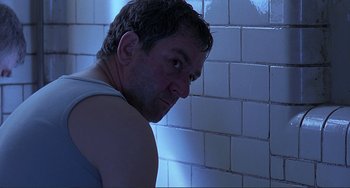 Movie still from “The Boxer” (1997), directed by Jim Sheridan – A person standing in front of a tiled wall; Close Up shot, Low angle