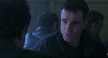 Movie still from “The Boxer” (1997), directed by Jim Sheridan – A person sitting in front of another person; Close Up shot, Over the shoulder angle