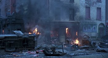 Movie still from “The Boxer” (1997), directed by Jim Sheridan – A building on fire in the middle of a street; Extreme Wide shot, High angle