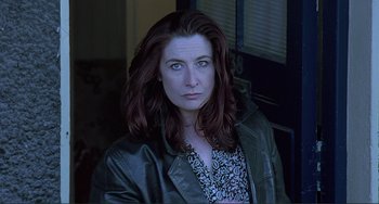 Movie still from “The Boxer” (1997), directed by Jim Sheridan – A person wearing a jacket; Close Up shot, Low angle