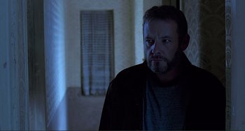 Movie still from “The Boxer” (1997), directed by Jim Sheridan – A person in a room near a window; Close Up shot, Low angle