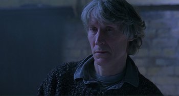 Movie still from “The Boxer” (1997), directed by Jim Sheridan – An older man is looking into the distance; Close Up shot, Low angle