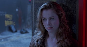 Movie still from “The Boxer” (1997), directed by Jim Sheridan – A beautiful woman with long blonde hair and blue eyes looking at the camera; Close Up shot, Over the shoulder angle