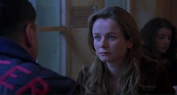 Movie still from “The Boxer” (1997), directed by Jim Sheridan – A woman sitting in front of a window looking to her left; Close Up shot, Over the shoulder angle