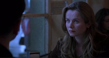 Movie still from “The Boxer” (1997), directed by Jim Sheridan – A woman sitting in front of a window looking into the distance; Close Up shot, Over the shoulder angle